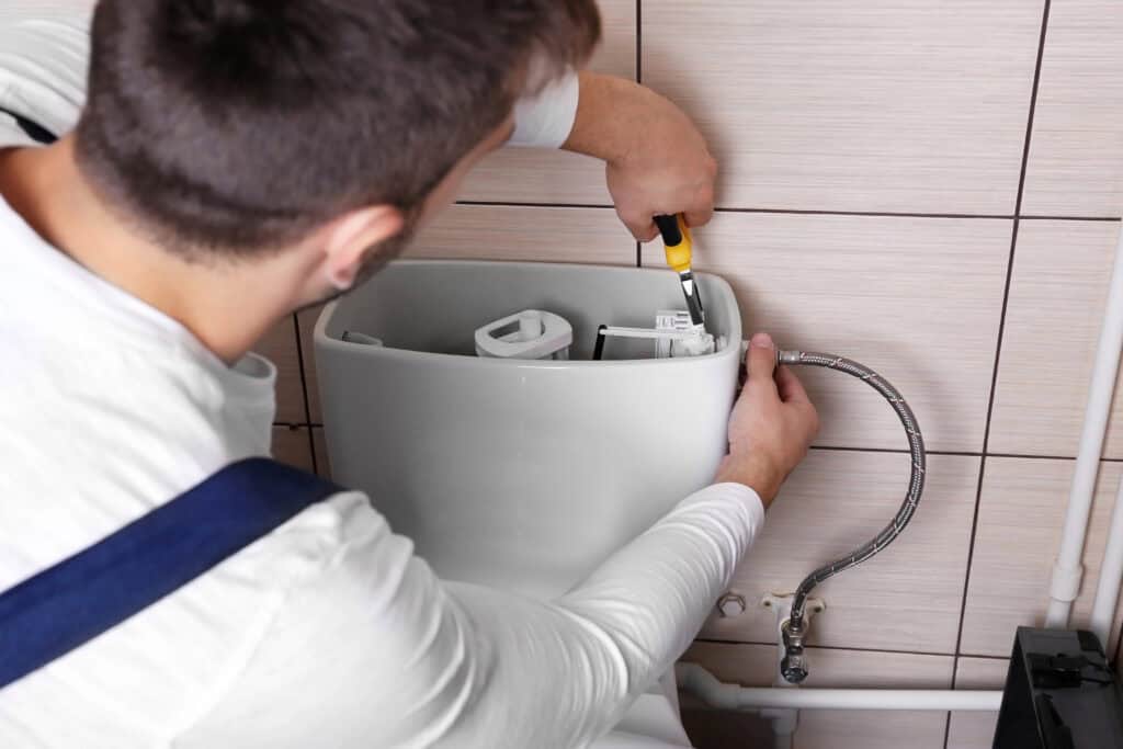 Plumber installing a toilet as part of HD Drain Cleaning's expert services in Ormond Beach, FL